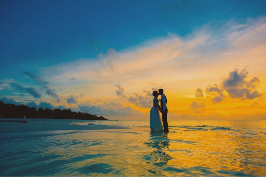 ビーチでキスをする結婚したての夫婦。このような特別な日に夜の営みをするなどといったセックスを必要以上に特別にする風潮があります。